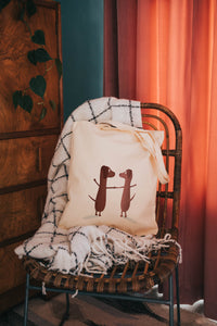 Picture of two dogs holding hands printed onto a long handle cotton bag 